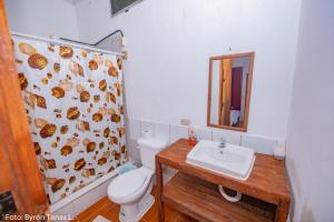 Un baño con inodoro, lavabo y espejo. en Linda Vista, en Río Dulce 36 fotos más