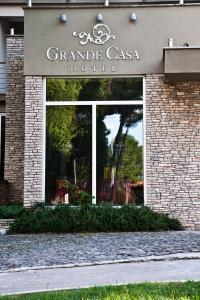 ein Schild des Grande casa Hotels vor einem Gebäude in der Unterkunft GRANDE CASA Hotel - Međugorje in Međugorje
