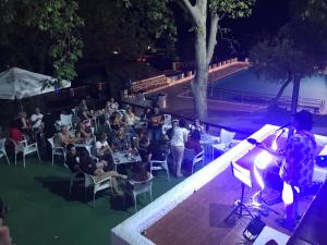 un groupe de personnes assises sur des chaises devant une foule dans l'établissement Hotel Rural & Restaurante Las Camaretas, à Cortes de la Frontera