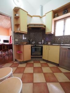 a kitchen with yellow cabinets and a tiled floor at Casa do Sol in Moledo