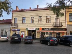 a large building with cars parked in front of it at Wonderful flat on city center (Mukachivska 4/15) in Uzhhorod