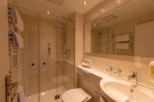 een badkamer met een douche, een toilet en een wastafel bij Parkhotel in Bad Waldsee