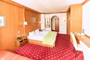a hotel room with a bed and a red carpet at Gasthof-Hotel Pietsch in Freystadt