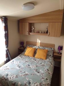 1 dormitorio con 1 cama con 2 almohadas de color naranja en Flamingo Land - Maple Grove MG32, en Kirby Misperton
