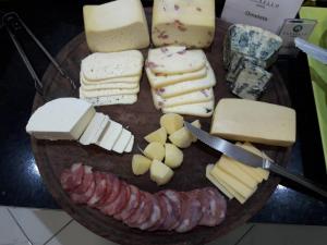un plato de diferentes tipos de queso y tocino en RAFAELLO HOTEL, en São Borja