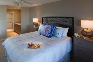 Un dormitorio con una cama con una bandeja de comida. en Hibiscus Oceanfront Resort, en St. Augustine Beach