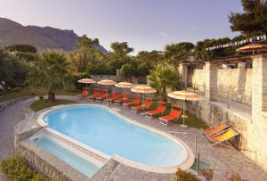a swimming pool with chairs and umbrellas at Casa Vacanze Parco Del Generale in Ischia
