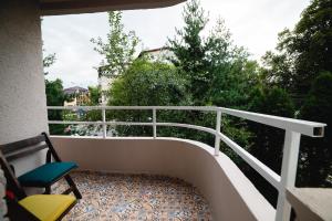 a balcony with a white railing and two chairs at Arca Sweet Apartment in Gura Humorului