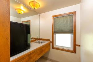 a bathroom with a large flat screen tv and a sink at River Rock Inn in Mariposa