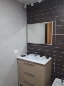 a bathroom with a sink and a mirror at Apartamento ÁTICO in Valdepeñas