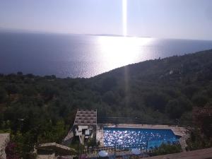 a swimming pool with the ocean in the background at Dio Guesthouses in Leonidion