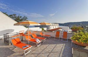 a patio with orange chairs and umbrellas on a roof at Casa Vacanze Parco Del Generale in Ischia