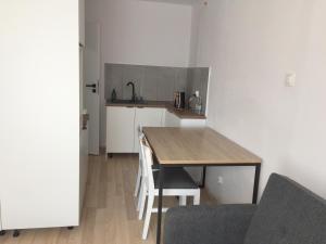 a small kitchen with a wooden table and chairs at Apartament loft Krzeszowice centrum in Krzeszowice