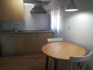 una cucina con tavolo in legno e lavandino di Olivia V a Tarragona