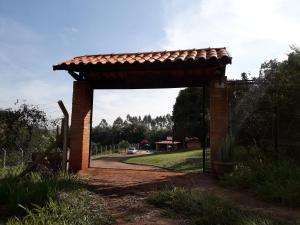 a brick archway with a roof over a road at Recanto do Nenê in Botucatu