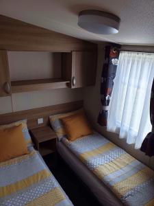 a small room with two beds and a window at Flamingo Land - Maple Grove MG32 in Kirby Misperton