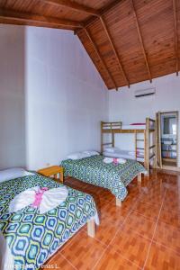 two beds in a room with wooden ceilings at Linda Vista in Río Dulce