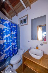 a bathroom with a sink and a toilet and a shower curtain at Linda Vista in Río Dulce