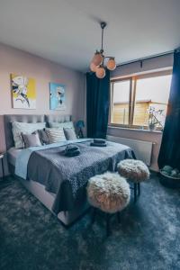1 dormitorio con 1 cama con 2 sillas y una ventana en Stylish apartments at Penati Golf Resort, en Šajdíkove Humence