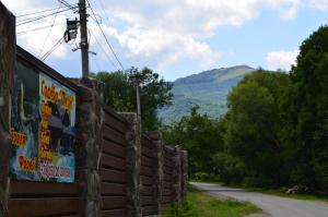 einen Zaun neben einer Straße mit einem Berg im Hintergrund in der Unterkunft Sadyba Pikuy in Belasovitsa