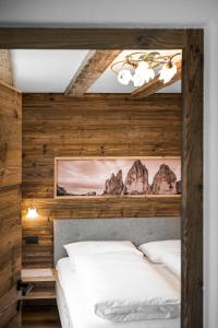 1 dormitorio con 2 camas blancas y paredes de madera en Chalet Dolomit, en San Lorenzo di Sebato
