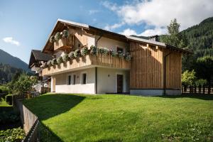 een huis met een groot gazon ervoor bij Chalet Dolomit in San Lorenzo di Sebato