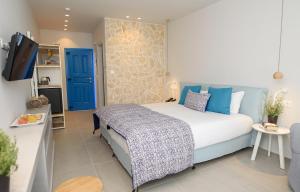 a bedroom with a bed and a tv in a room at Vigla Hotel in Aegiali