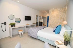 a bedroom with a bed and a desk and a tv at Vigla Hotel in Aegiali +37 photos