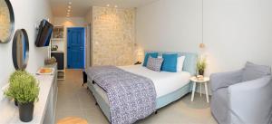 a bedroom with a bed with blue pillows at Vigla Hotel in Aegiali