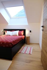 a bedroom with a bed with a skylight at Alpine Home Fiemme in Predazzo