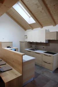 a large kitchen with white cabinets and a skylight at Alpine Home Fiemme in Predazzo