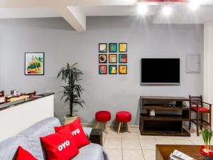 a living room with a couch and a flat screen tv at OYO Hotel Nobrega Aeroporto de Congonhas, São Paulo in Sao Paulo
