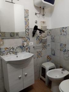 a bathroom with a sink and a toilet at Casa Vico Lepre in Noto