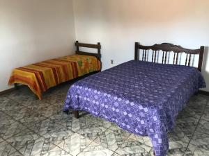 a bedroom with a bed in a room at Chacara estilo Chale in Roças Novas