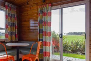 una camera con tavolo, sedie e finestra di Little Wanganui Hotel a Little Wanganui