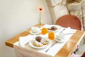 a table topped with plates of donuts and orange juice at Garni il Concale in Castel di Sangro