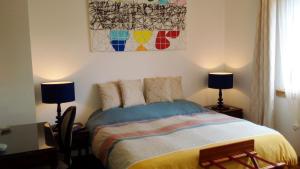 1 dormitorio con 1 cama con 2 lámparas y 1 pintura en LE MASSITROU - chambre d'hôte - Table d'hôte, en Nedde