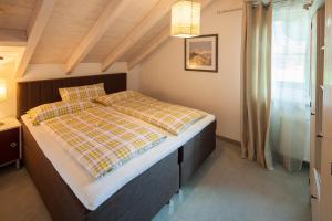 ein Schlafzimmer mit einem Bett mit einer karierten Decke in der Unterkunft Ferienwohnungen Weidach in Oberstdorf