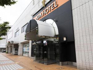 un magasin avec un panneau sur le côté d'un bâtiment dans l'établissement APA Hotel Yamagata Tsuruoka Ekimae, à Tsuruoka