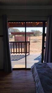 a bedroom with a door open to a porch with a deck at StableWood Lodge in Kimberley