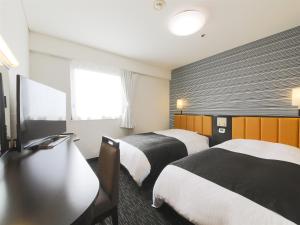 Rúm í herbergi á APA Hotel Yamagata Tsuruoka Ekimae