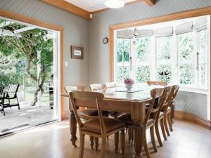 a dining room with a wooden table and chairs at Goodin Country Garden in Okato