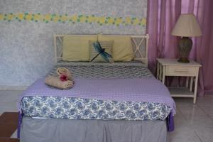 un osito de peluche sentado en una cama en un dormitorio en Posada del Mar, en La Parguera