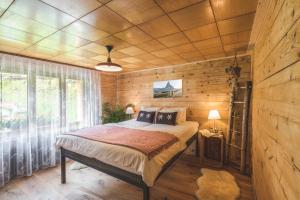 una camera con un letto in una stanza con pareti in legno di Aroleid Lodge a Zermatt