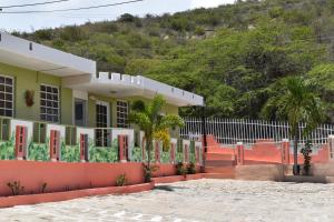 une maison avec des portes rouges et une clôture dans l'établissement Posada del Mar, à La Parguera
