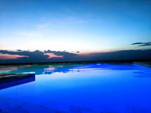 una piscina de agua azul con la puesta de sol en el fondo en Bentrina Diving Resort, en Mabini