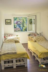 2 camas en una habitación con ventana en Guesthouse Edelnice, en Gornja Trepča