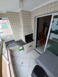 a view of a bathroom with a table and a couch at Cantinho do Churrasco - Varanda Gourmet a 60 mts praia in Praia Grande