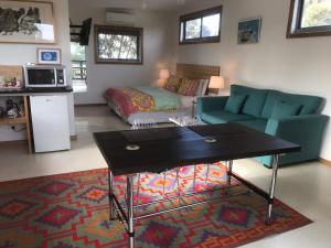 een woonkamer met een bank en een tafel bij Phillip Island self check in in Ventnor