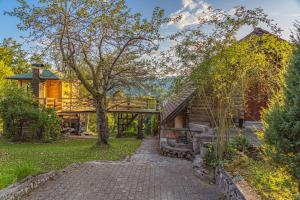 una casa con un árbol y una pasarela en Grey green and fun 4 YOU - 2 Cottages, en Drganja Sela